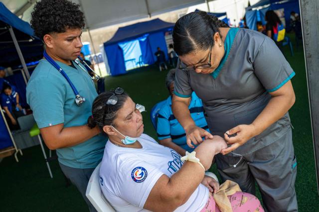 A displaced woman receives medical care at a temporary shelter set up at the Jose Maria Vargas sports complex in Catia la Mar, La Guaira state, Venezuela, on July 6, 2026, following the June 24 earthquakes. The twin earthquakes that struck Venezuela on June 24 have claimed the lives of at least 3,535 people, the Venezuelan government reported on July 5. (Photo by Miguel MEDINA / AFP)