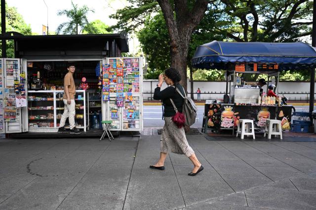 A woman walks past street stalls in Chacao municipality, in Caracas, on July 6, 2026, following the June 24 earthquakes that hit the region. The death toll from Venezuela's twin earthquakes has risen to 3,535, with more than 16,700 injured in the disaster, according to updated official figures released on July 6. (Photo by Raul ARBOLEDA / AFP)