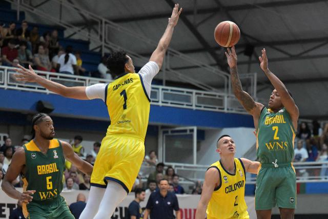 Brazil's Yago Santos (R) attempts a three point basket past Colombia's Juan Cardenas during the FIBA Basketball World Cup 2027 Americas qualifiers Group C match between Colombia and Brazil, at the Evangelista Mora Colisseum in Cali, Valle del Cauca, Colombia, on July 6, 2026. (Photo by JOAQUIN SARMIENTO / AFP)
