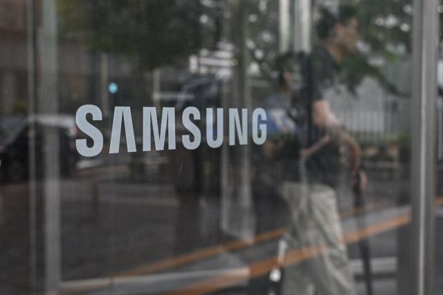 The logo of Samsung is seen at the Samsung Electronics Seocho building in Seoul on July 7, 2026. South Korean technology giant Samsung Electronics forecast on July 7 a roughly 19-fold jump in second-quarter operating profit from a year earlier, buoyed by sustained AI-driven demand for memory chips. (Photo by Jade GAO / AFP)