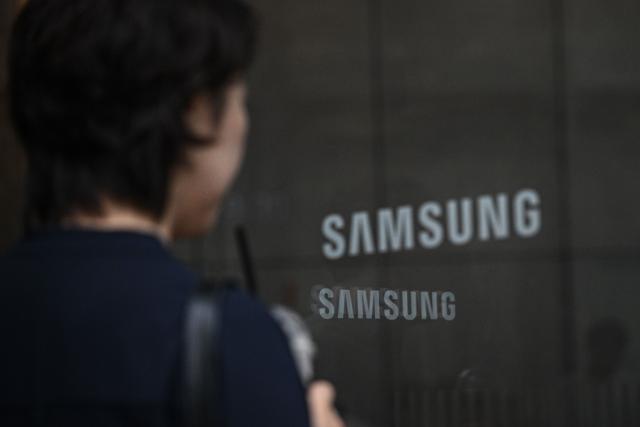 The logo of Samsung is seen at the Samsung Electronics Seocho building in Seoul on July 7, 2026. South Korean technology giant Samsung Electronics forecast on July 7 a roughly 19-fold jump in second-quarter operating profit from a year earlier, buoyed by sustained AI-driven demand for memory chips. (Photo by Jade GAO / AFP)
