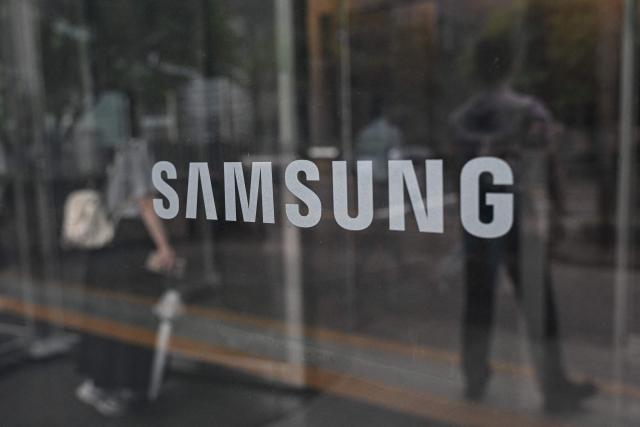 The logo of Samsung is seen at the Samsung Electronics Seocho building in Seoul on July 7, 2026. South Korean technology giant Samsung Electronics forecast on July 7 a roughly 19-fold jump in second-quarter operating profit from a year earlier, buoyed by sustained AI-driven demand for memory chips. (Photo by Jade GAO / AFP)