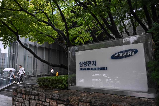 Signage of Samsung Electronics is displayed outside the company's Seocho building in Seoul on July 7, 2026. South Korean technology giant Samsung Electronics forecast on July 7 a roughly 19-fold jump in second-quarter operating profit from a year earlier, buoyed by sustained AI-driven demand for memory chips. (Photo by Jade GAO / AFP)