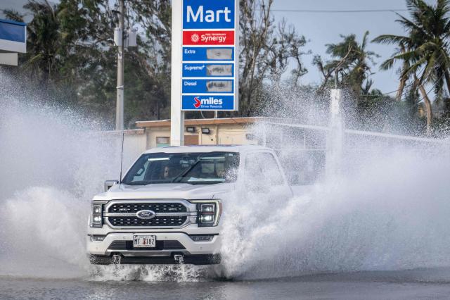 A motorist drives through a flooded road after heavy rain brought by Super Typhoon Bavi in Guam on July 7, 2026. (Photo by Yuichi YAMAZAKI / AFP)
