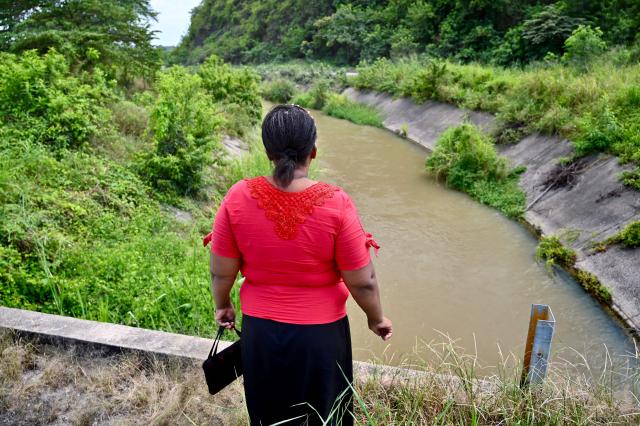 Ecuadorean Eva Sevillano, an evangelical pastor and resident of the Nueva Prosperina neighborhood, stands at the popularly known as the Canal de la Muerte (Death Canal), in northwest Guayaquil, Ecuador, on June 29, 2026. Hundreds of bodies linked to kidnapping victims, criminal acts, and clashes between gangs have been found at he Canal de la Muerte -a section of the Daule–Santa Elena transfer canal. (Photo by MARCOS PIN / AFP)