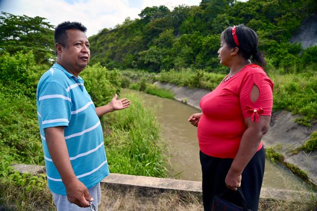 Ecuadorean Eva Sevillano, an evangelical pastor and resident of the Nueva Prosperina neighborhood, and her husband  Pedro Vazques stand at the popularly known as the Canal de la Muerte (Death Canal), in northwest Guayaquil, Ecuador, on June 29, 2026. Hundreds of bodies linked to kidnapping victims, criminal acts, and clashes between gangs have been found at he Canal de la Muerte -a section of the Daule–Santa Elena transfer canal. (Photo by MARCOS PIN / AFP)