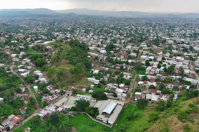 This aerial view shows Nueva Prosperina neighbourhood where the popularly known as the Canal de la Muerte (Death Canal) is located, in northwest Guayaquil, Ecuador, on June 12, 2026. Hundreds of bodies linked to kidnapping victims, criminal acts, and clashes between gangs have been found at he Canal de la Muerte -a section of the Daule–Santa Elena transfer canal. (Photo by MARCOS PIN / AFP)