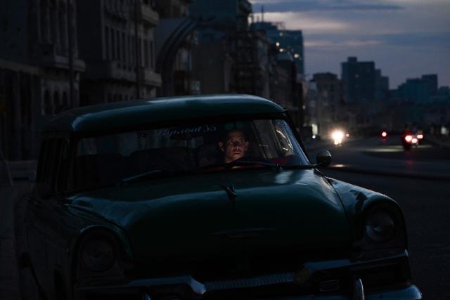 A man sits inside a vintage car during a nationwide blackout in Havana on July 6, 2026. Cuba on July 6 suffered its third nationwide power outage since the start of the year, the state electricity company said. The impoverished island was already struggling to keep the lights on before US President Donald Trump in January imposed an oil blockade, which has depleted the already dwindling supply of fuel for Cuba's power plants. (Photo by YAMIL LAGE / AFP)
