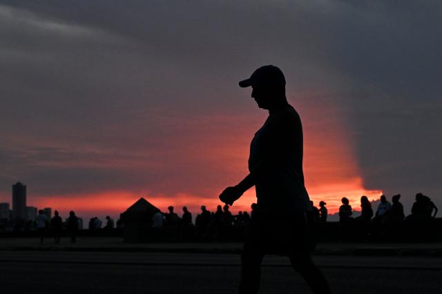 A man walks along the Malecon during a nationwide blackout in Havana on July 6, 2026. Cuba on July 6 suffered its third nationwide power outage since the start of the year, the state electricity company said. The impoverished island was already struggling to keep the lights on before US President Donald Trump in January imposed an oil blockade, which has depleted the already dwindling supply of fuel for Cuba's power plants. (Photo by YAMIL LAGE / AFP)