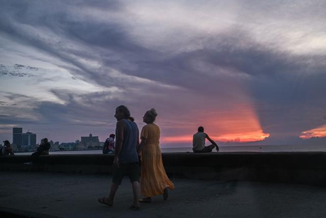 People walk along the Malecon during a nationwide blackout in Havana on July 6, 2026. Cuba on July 6 suffered its third nationwide power outage since the start of the year, the state electricity company said. The impoverished island was already struggling to keep the lights on before US President Donald Trump in January imposed an oil blockade, which has depleted the already dwindling supply of fuel for Cuba's power plants. (Photo by ADALBERTO ROQUE / AFP)