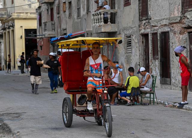 A man rides a pedal-powered tricycle along a street during a nationwide blackout in Havana on July 6, 2026. Cuba on July 6 suffered its third nationwide power outage since the start of the year, the state electricity company said. The impoverished island was already struggling to keep the lights on before US President Donald Trump in January imposed an oil blockade, which has depleted the already dwindling supply of fuel for Cuba's power plants. (Photo by YAMIL LAGE / AFP)
