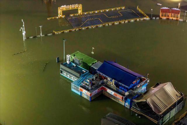 Flooded shops are seen near a wharf on the Yongjiang river in Nanning, in China’s southern Guangxi region on July 6, 2026. Heavy rains and severe flooding from Typhoon Maysak killed at least two people in the southern region of Guangxi, and prompted authorities to evacuate at least 48,000 people as of July 6 evening. (Photo by CN-STR / AFP) / China OUT