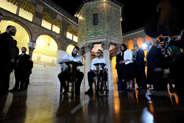 Syrian President Ahmed Al-Charaa (L) signs a book next to France's President Emmanuel Macron during a visit to the Umayyad Mosque in Damascus, on July 6, 2026. French President Emmanuel Macron arrived in Damascus on July 6, 2026 for the first visit by a Western European head of state since Syria's new authorities took power in 2024, an AFP journalist said. Macron, who will depart on July 7, 2026, will advocate for "a free, pluralist Syria that respects each of its components" and plays a role in moderating Middle East tensions, the French presidency told journalists ahead of his arrival. (Photo by Ludovic MARIN / AFP)