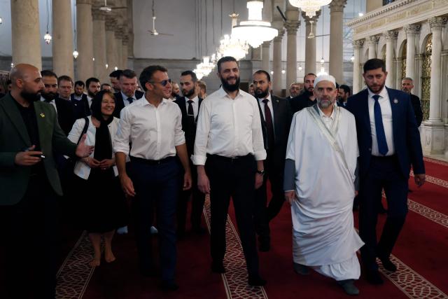 France's President Emmanuel Macron (L) and Syrian President Ahmed Al-Charaa (C) visit the Umayyad Mosque in Damascus, on July 6, 2026. French President Emmanuel Macron arrived in Damascus on July 6, 2026 for the first visit by a Western European head of state since Syria's new authorities took power in 2024, an AFP journalist said. Macron, who will depart on July 7, 2026, will advocate for "a free, pluralist Syria that respects each of its components" and plays a role in moderating Middle East tensions, the French presidency told journalists ahead of his arrival. (Photo by Ludovic MARIN / AFP)