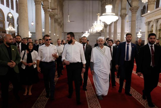 France's President Emmanuel Macron (L) and Syrian President Ahmed Al-Charaa (C) visit the Umayyad Mosque in Damascus, on July 6, 2026. French President Emmanuel Macron arrived in Damascus on July 6, 2026 for the first visit by a Western European head of state since Syria's new authorities took power in 2024, an AFP journalist said. Macron, who will depart on July 7, 2026, will advocate for "a free, pluralist Syria that respects each of its components" and plays a role in moderating Middle East tensions, the French presidency told journalists ahead of his arrival. (Photo by Ludovic MARIN / AFP)