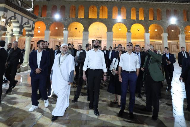 France's President Emmanuel Macron (2nd/R) and Syrian President Ahmed Al-Charaa (C) visit the Umayyad Mosque in Damascus, on July 6, 2026. French President Emmanuel Macron arrived in Damascus on July 6, 2026 for the first visit by a Western European head of state since Syria's new authorities took power in 2024, an AFP journalist said. Macron, who will depart on July 7, 2026, will advocate for "a free, pluralist Syria that respects each of its components" and plays a role in moderating Middle East tensions, the French presidency told journalists ahead of his arrival. (Photo by Ludovic MARIN / AFP)