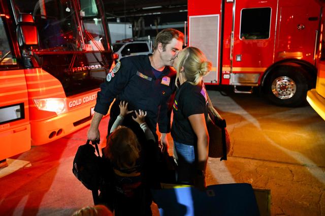 A member of the Los Angeles County Fire Department USA-2 international urban search and rescue team is reunited with his family after returning from rescue efforts following the earthquakes in Venezuela at the LACoFD Technical Operations Section in Los Angeles, California on July 6, 2026. (Photo by Patrick T. Fallon / AFP)