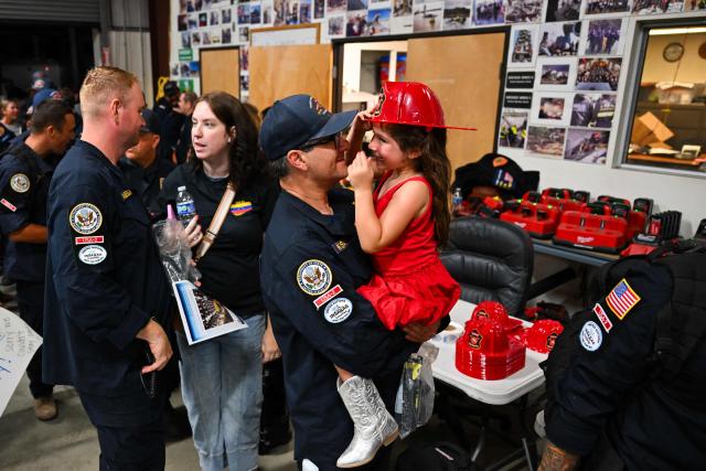 A member of the Los Angeles County Fire Department USA-2 international urban search and rescue team is reunited with his family after returning from rescue efforts following the earthquakes in Venezuela at the LACoFD Technical Operations Section in Los Angeles, California on July 6, 2026. (Photo by Patrick T. Fallon / AFP)
