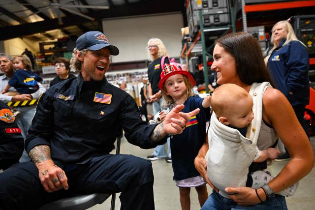 A member of the Los Angeles County Fire Department USA-2 international urban search and rescue team is reunited with his family after returning from rescue efforts following the earthquakes in Venezuela at the LACoFD Technical Operations Section in Los Angeles, California on July 6, 2026. (Photo by Patrick T. Fallon / AFP)