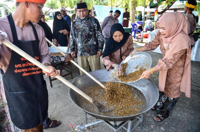 Muslim participants prepare a large dish of azura, a traditional dessert eaten during Ashura commemorations in the first month of the Islamic lunar year, at an event organized by the Provincial Islamic Committee in southern Thailand's Narathiwat province on July 7, 2026. (Photo by Madaree TOHLALA / AFP)