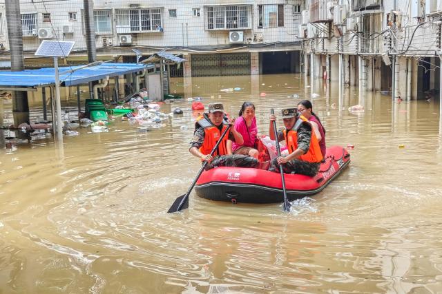 Paramilitary police evacuate flood-affected residents in Nanning, in China's southern Guangxi region on July 6, 2026. The death toll from devastating storms in parts of China rose to 15 on July 7, with hundreds more injured and tens of thousands evacuated, state media reported, as President Xi Jinping urged "all out" rescue efforts. (Photo by CNS / AFP) / China OUT