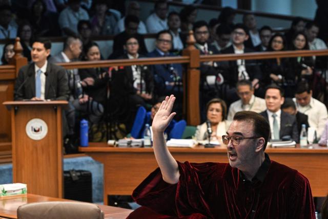 Philippine Senator Alan Peter Cayetano raises his hands to give a statement during the impeachment trial of Philippine Vice President Sara Duterte at the Senate of the Philippines in Pasay, Metro Manila on July 7, 2026. (Photo by NOEL CELIS / POOL / AFP)