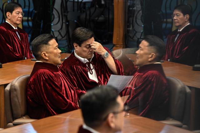 Philippine Senators, acting judges of the impeachment court, are reflected on a surface as they attend the impeachment trial of Philippine Vice President Sara Duterte at the Senate of the Philippines in Pasay, Metro Manila on July 7, 2026. (Photo by NOEL CELIS / POOL / AFP)