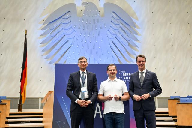 Stefan Wrobel (L), director of Lamarr Institute and North Rhine-Westphalia's State Premier Hendrik Wuest (R) pose with Jaroslaw Kutylowski, CEO and founder of German AI research company DeepL known for its language AI platform including DeepL Translator and for DeepL Agent, after he was presented the Lamarr Award during the Lamarr Conference at the World Conference Centre in Bonn, western Germany, on July 7, 2026. The Lamarr Conference is an international conference on artificial intelligence running from July 7-8 and bringing together "those shaping scientific foundations and those translating AI advances into tangible impact". In recognition of his achievements in AI research, development and knowledge transfer, the 2026 Lamarr Award will be presented to Jaroslaw Kutylowski. (Photo by Ina FASSBENDER / AFP)