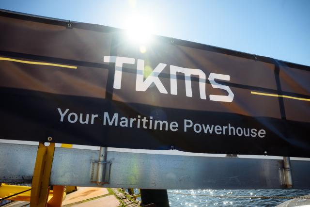 (FILES) The sun shines behind the logo of TKMS (ThyssenKrupp Marine Systems) at their submarine shipyard, in Kiel, northern Germany on April 22, 2026. Canada has chosen Germany's Thyssenkrupp Marine Systems TKMS to build its new multi-billion-dollar fleet of submarines, Canada's Prime Minister said on July 6, 2026, as his government works to deepen defence ties with European NATO allies. (Photo by Gregor Fischer / AFP)