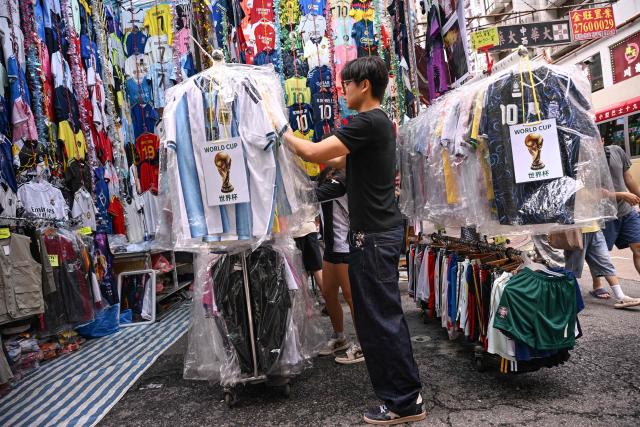 A customer looks at unlicensed football jerseys on sale in a street market in Hong Kong on July 7 2026. (Photo by Peter PARKS / AFP)