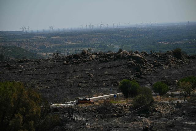 This photograph shows a firefighter vehicle in burnt area as a wildfire rages in the southern France department of Pyrenees-Orientales near the town of Ille-sur-Tet, near Perpignan, on July 7, 2026. The wildfire in the Pyrenees-Orientales, which has already burned 4,900 hectares not far from Perpignan but did not spread overnight—thanks in large part to backfires set by firefighters—has led to the evacuation of a total of 12,000 people, the department’s prefect said on July 7, 2026. (Photo by Lionel BONAVENTURE / AFP)