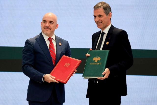Chief Executive Officer of Syrian Airlines Anwar Al-Akkad (L) and CMA CGM Group Chairman and CEO Rodolphe Saade pose holding the Memorandum of Understanding on the handling of 
air freight at Damascus International Airport during an agreement signing ceremony in Damascus on July 7, 2026.. French President Emmanuel Macron arrived in Damascus on July 6, 2026 for the first visit by a Western European head of state since Syria's new authorities took power in 2024, an AFP journalist said. Macron, who will depart on July 7, 2026, will advocate for "a free, pluralist Syria that respects each of its components" and plays a role in moderating Middle East tensions, the French presidency told journalists ahead of his arrival. (Photo by Ludovic MARIN / POOL / AFP)