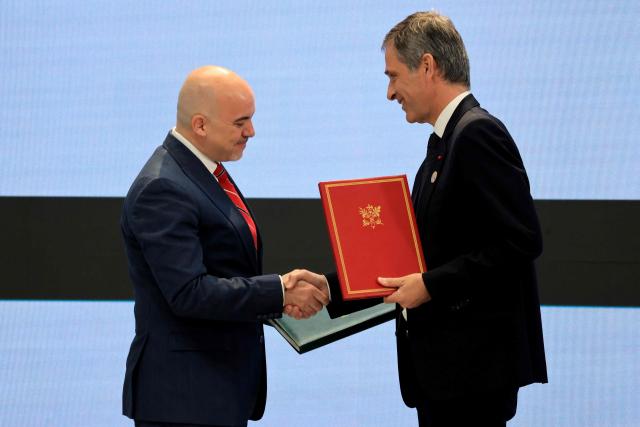 Chief Executive Officer of Syrian Airlines Anwar Al-Akkad (L) and CMA CGM Group Chairman and CEO Rodolphe Saade pose holding the Memorandum of Understanding on the handling of 
air freight at Damascus International Airport during an agreement signing ceremony in Damascus on July 7, 2026.. French President Emmanuel Macron arrived in Damascus on July 6, 2026 for the first visit by a Western European head of state since Syria's new authorities took power in 2024, an AFP journalist said. Macron, who will depart on July 7, 2026, will advocate for "a free, pluralist Syria that respects each of its components" and plays a role in moderating Middle East tensions, the French presidency told journalists ahead of his arrival. (Photo by Ludovic MARIN / POOL / AFP)