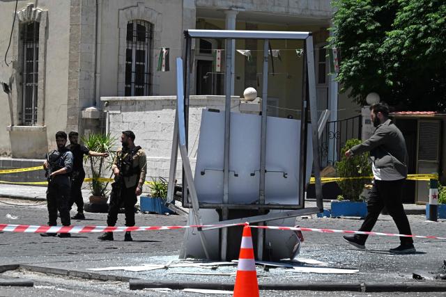 Security personnel stand guard near the Four Seasons Hotel following two blasts nearby in Damascus on July 7, 2026. Two explosions shook Damascus on July 7 near a hotel where French President Emmanuel Macron was staying, wounding at least 18 people, during the French leader's landmark visit to Syria. (Photo by LOUAI BESHARA / AFP)