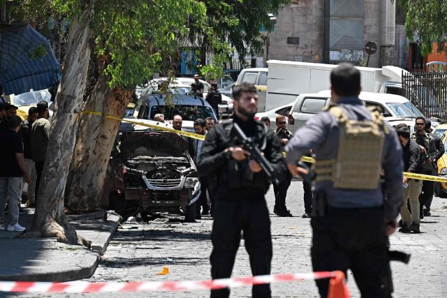 Security personnel stand guard near the Four Seasons Hotel following two blasts nearby in Damascus on July 7, 2026. Two explosions shook Damascus on July 7 near a hotel where French President Emmanuel Macron was staying, wounding at least 18 people, during the French leader's landmark visit to Syria. (Photo by LOUAI BESHARA / AFP)