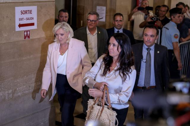 (From L) President of Rassemblement National parliamentary group Marine Le Pen, Perpignan's mayor Louis Aliot and Member of the European Parliament Catherine Griset arrive to attend the verdict in the appeal trial of RN former or actual members on charges of embezzlement of European public funds in a case of alleged European Parliament fake jobs at Paris Court of Appeal on July 7, 2026. A lower court last year sentenced longtime party leader and three-time presidential candidate, Marine Le Pen, to a five-year ban from public office and two years in prison over a fake jobs scam at the European Parliament. The appeals court will rule on whether to uphold the ban in a case that has upended her presidential aspirations. (Photo by Kenzo TRIBOUILLARD / AFP)