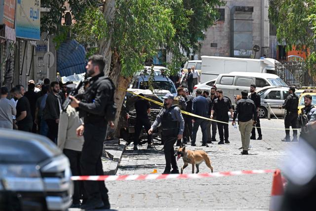 A security personnel along with a sniffer dog inspects near the Four Seasons Hotel following two blasts, in Damascus on July 7, 2026. Two explosions shook Damascus on July 7 near a hotel where French President Emmanuel Macron was staying, wounding at least 18 people, during the French leader's landmark visit to Syria. (Photo by LOUAI BESHARA / AFP)