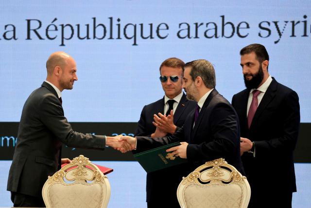 France's Foreign Affairs Minister Jean-Noel Barrot (L) and Syria's Foreign Minister Asaad al-Shaibani (2nd R) shake hands flanked by France's President Emmanuel Macron (2nd L) and Syria's Foreign Minister Asaad al-Shaibani after signing the Framework Agreement on Bilateral Cooperation during an agreement signing ceremony in Damascus on July 7, 2026. French President Emmanuel Macron arrived in Damascus on July 6, 2026 for the first visit by a Western European head of state since Syria's new authorities took power in 2024, an AFP journalist said. Macron, who will depart on July 7, 2026, will advocate for "a free, pluralist Syria that respects each of its components" and plays a role in moderating Middle East tensions, the French presidency told journalists ahead of his arrival. (Photo by Ludovic MARIN / POOL / AFP)