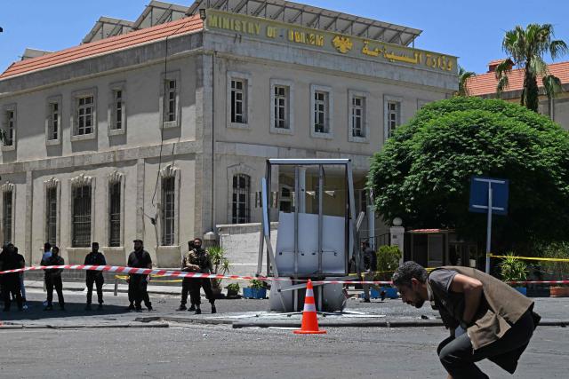 Security personnel stand guard near the Four Seasons Hotel following two blasts nearby in Damascus on July 7, 2026. Two explosions shook Damascus on July 7 near a hotel where French President Emmanuel Macron was staying, wounding at least 18 people, during the French leader's landmark visit to Syria. (Photo by LOUAI BESHARA / AFP)