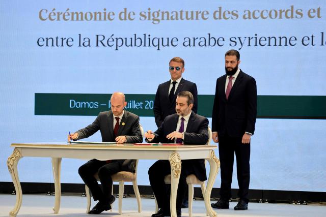 France's Foreign Affairs Minister Jean-Noel Barrot (L) and Syria's Foreign Minister Asaad al-Shaibani (2nd R) sign the Framework Agreement on Bilateral Cooperation flanked by France's President Emmanuel Macron (2nd L) and Syria's Foreign Minister Asaad al-Shaibani during an agreement signing ceremony in Damascus on July 7, 2026. French President Emmanuel Macron arrived in Damascus on July 6, 2026 for the first visit by a Western European head of state since Syria's new authorities took power in 2024, an AFP journalist said. Macron, who will depart on July 7, 2026, will advocate for "a free, pluralist Syria that respects each of its components" and plays a role in moderating Middle East tensions, the French presidency told journalists ahead of his arrival. (Photo by Ludovic MARIN / POOL / AFP)