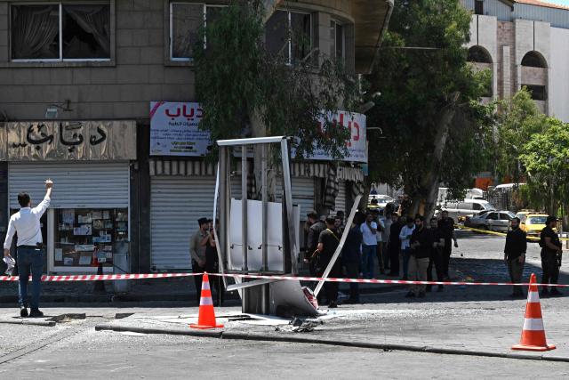 Security personnel stand guard near the Four Seasons Hotel following two blasts nearby in Damascus on July 7, 2026. Two explosions shook Damascus on July 7 near a hotel where French President Emmanuel Macron was staying, wounding at least 18 people, during the French leader's landmark visit to Syria. (Photo by LOUAI BESHARA / AFP)