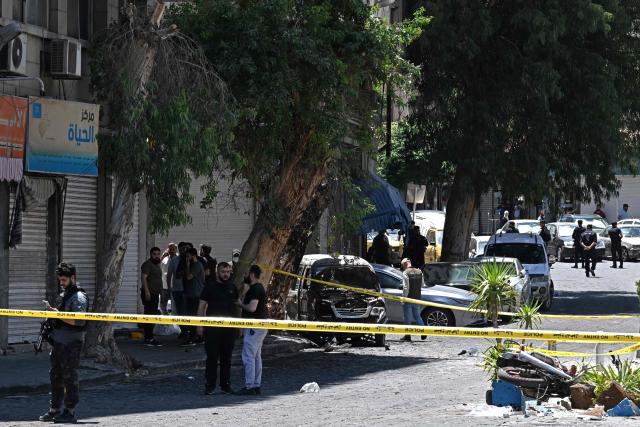 Security personnel stand guard near the Four Seasons Hotel following two blasts nearby in Damascus on July 7, 2026. Two explosions shook Damascus on July 7 near a hotel where French President Emmanuel Macron was staying, wounding at least 18 people, during the French leader's landmark visit to Syria. (Photo by LOUAI BESHARA / AFP)