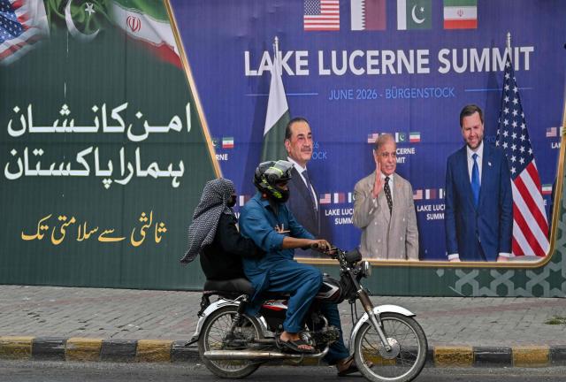 A family rides past a billboard featuring Pakistan's Prime Minister Shehbaz Sharif, Pakistan's Chief of Army Staff Field Marshal Asim Munir and the US Vice President JD Vance in Lahore on July 7, 2026 during the Lake Lucerne Summit in Switzerland earlier in June. (Photo by Arif ALI / AFP)