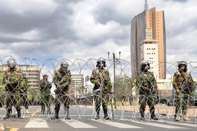 Police take position behind a temporary barricade erected outside parliament buildings in anticipation of anti-government protests to commemorate the struggle against government oppression on annual day of protest known as Saba-saba in Nairobi on July 07, 2026. Kenyan police banned a march to mark an annual day of protest on Tuesday, using plainclothes officers and unmarked cars to drag away even the tiny group that managed to assemble.
The Kenyan government of President William Ruto has taken a zero-tolerance attitude to even the slightest hint of protest after massive and deadly demonstrations over the past two years. (Photo by Tony KARUMBA / AFP)