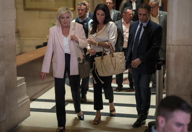 President of Rassemblement National parliamentary group Marine Le Pen (L) flanked by Member of the European Parliament Catherine Griset (R) leave after the verdict in the appeal trial of RN former or actual members on charges of embezzlement of European public funds in a case of alleged European Parliament fake jobs at Paris Court of Appeal on July 7, 2026. An appeals court on July 7, 2026, handed France's far-right chief Marine Le Pen a one-year term with an ankle tag over a fake jobs scam in the European parliament, casting doubt on whether she will run for president next April. The court also prevented her from running for office for 15 months, a ban expected to have expired this year. (Photo by Kenzo TRIBOUILLARD / AFP)