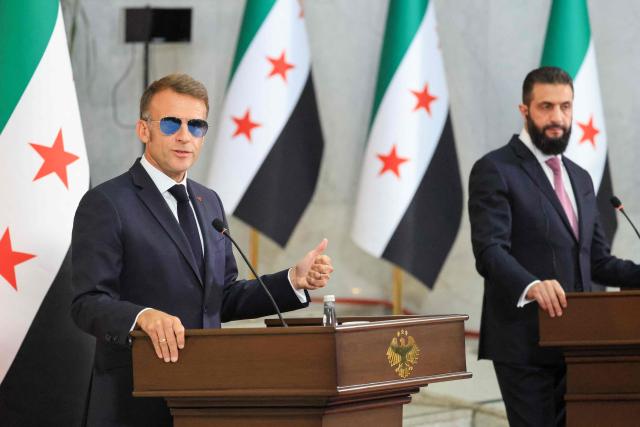 France's President Emmanuel Macron (L) and Syrian President Ahmed al-Sharaa give a joint press conference in Damascus on July 7, 2026. French President Emmanuel Macron arrived in Damascus on July 6, 2026 for the first visit by a Western European head of state since Syria's new authorities took power in 2024, an AFP journalist said. Macron, who will depart on July 7, 2026, will advocate for "a free, pluralist Syria that respects each of its components" and plays a role in moderating Middle East tensions, the French presidency told journalists ahead of his arrival. (Photo by Ludovic MARIN / POOL / AFP)