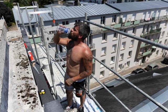 A worker drinks water in Brest, western France, on July 7, 2026 as another heatwave hits France. (Photo by Fred TANNEAU / AFP)