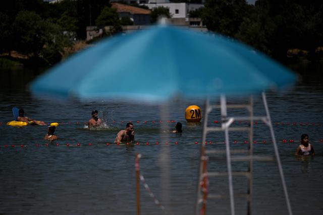 Bathers cool off at the Bègles lake in Bègles, on the outskirts of Bordeaux, south-western France on July 7, 2026, as another heatwave hits France. (Photo by Christophe ARCHAMBAULT / AFP)