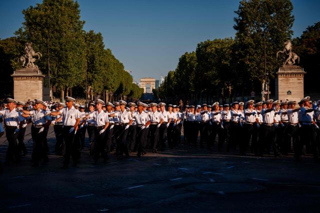 French Marine Nationale soldiers (French Navy) parade during a rehearsal of the annual Bastille Day military parade down the Champs Elysees Avenue, with the Arc de Triomphe in the background in Paris on July 8, 2026. (Photo by Dimitar DILKOFF / AFP)