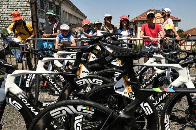 Spectators lining the race route look at parked bicycles at the start of the 5th stage of the 113th edition of the Tour de France cycling race, 158 km between Lannemezan and Pau in southwestern France, on July 8, 2026. (Photo by Jeff PACHOUD / AFP)